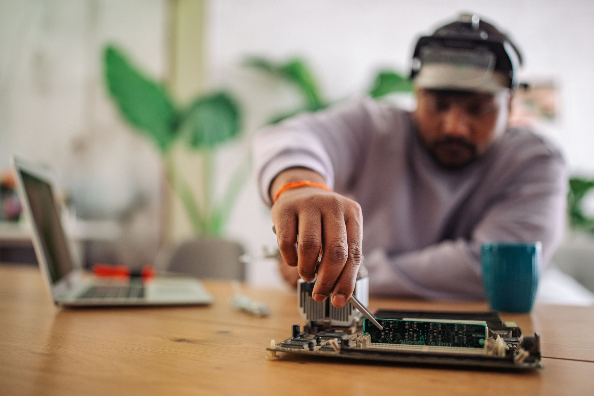 Indian technician repairing electronic board at home