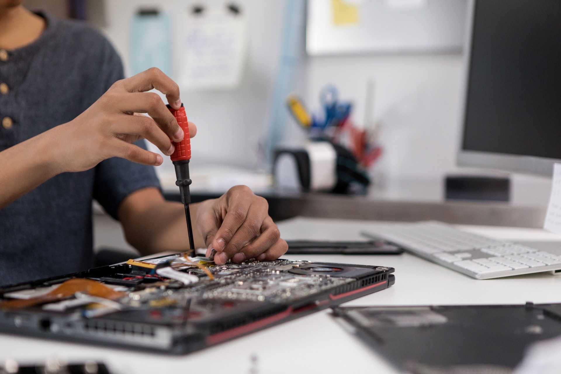 Teenage boy repairs laptop