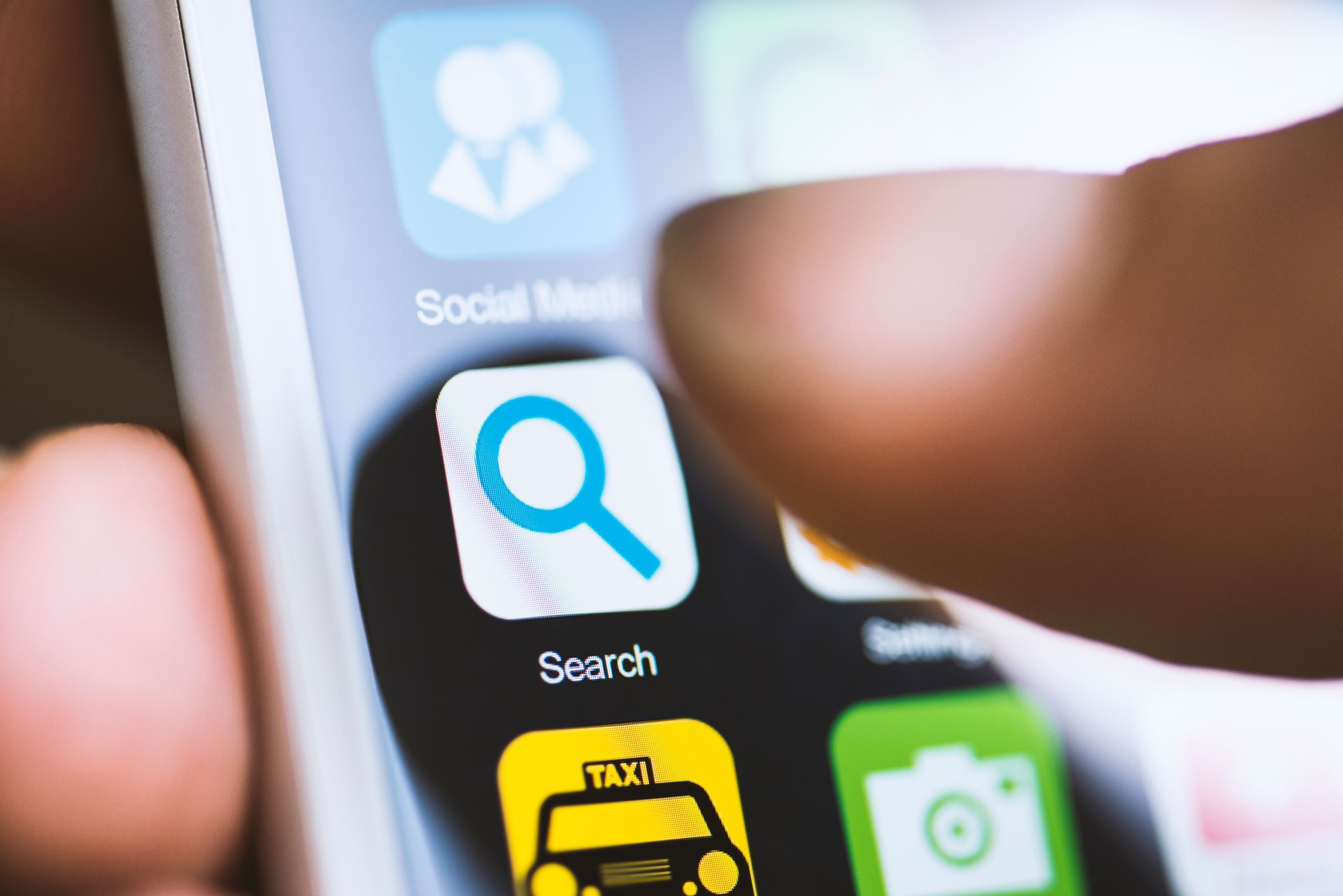 Hand touching search app on screen